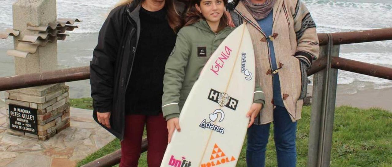 Adela Bas, Kenia López y Covadonga Obegero junto al monumento en honor a Peter Gulley, en la playa de Tapia.