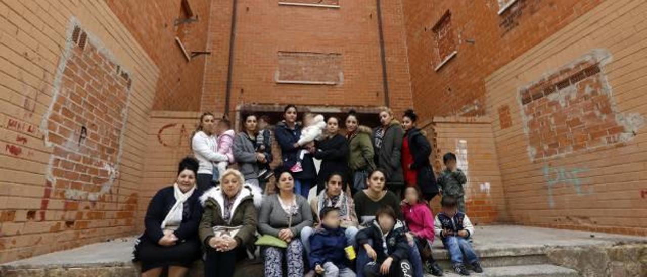 Familias que ocuparon de forma ilegal pisos de la Coma y que la Generalitat quiere desalojarlas, frente a un edificio totalmente vacío.