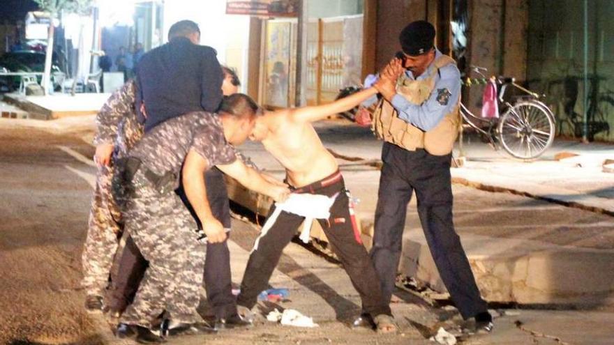 Fuerzas de seguridad iraquíes retiran del cuerpo de un niño un cinturón con explosivos. // Reuters