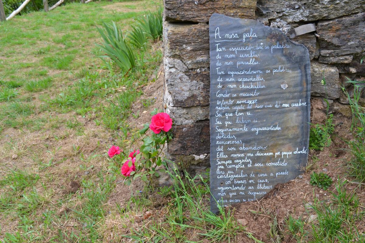 Un poema en fala y escrito sobre pizarrra, puede leerse junto a la capilla.