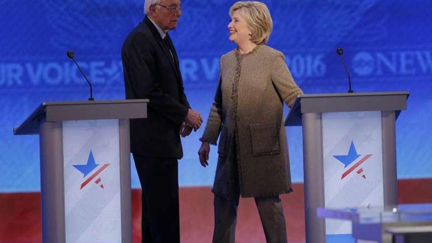 Clinton y Sanders conversan en una pausa del debate. // Reuters