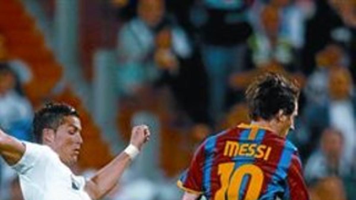 Messi se escapa de la presión de Cristiano Ronaldo, ayer en Madrid.