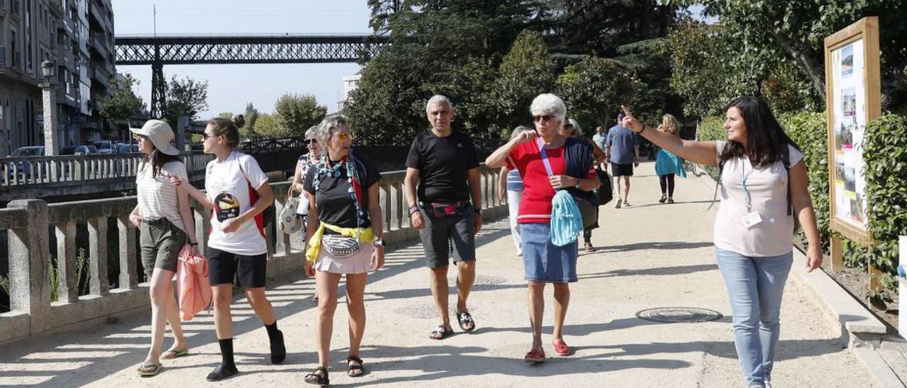 Turistas y peregrinos participan en un paseo vespertino por la villa guiados por la técnica de Turismo (dcha.), Patricia Mata.   | // JOSE LORES