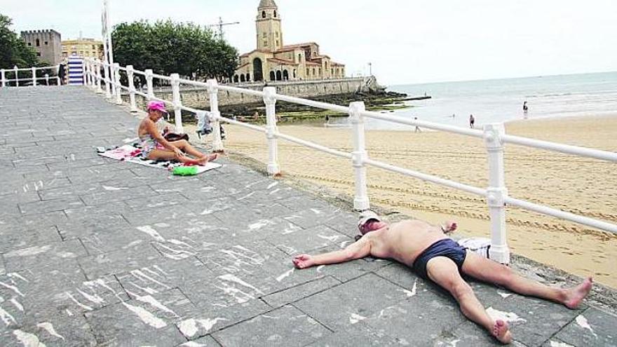 Un hombre toma el sol en la rampa de la escalera número 2 de San Lorenzo.