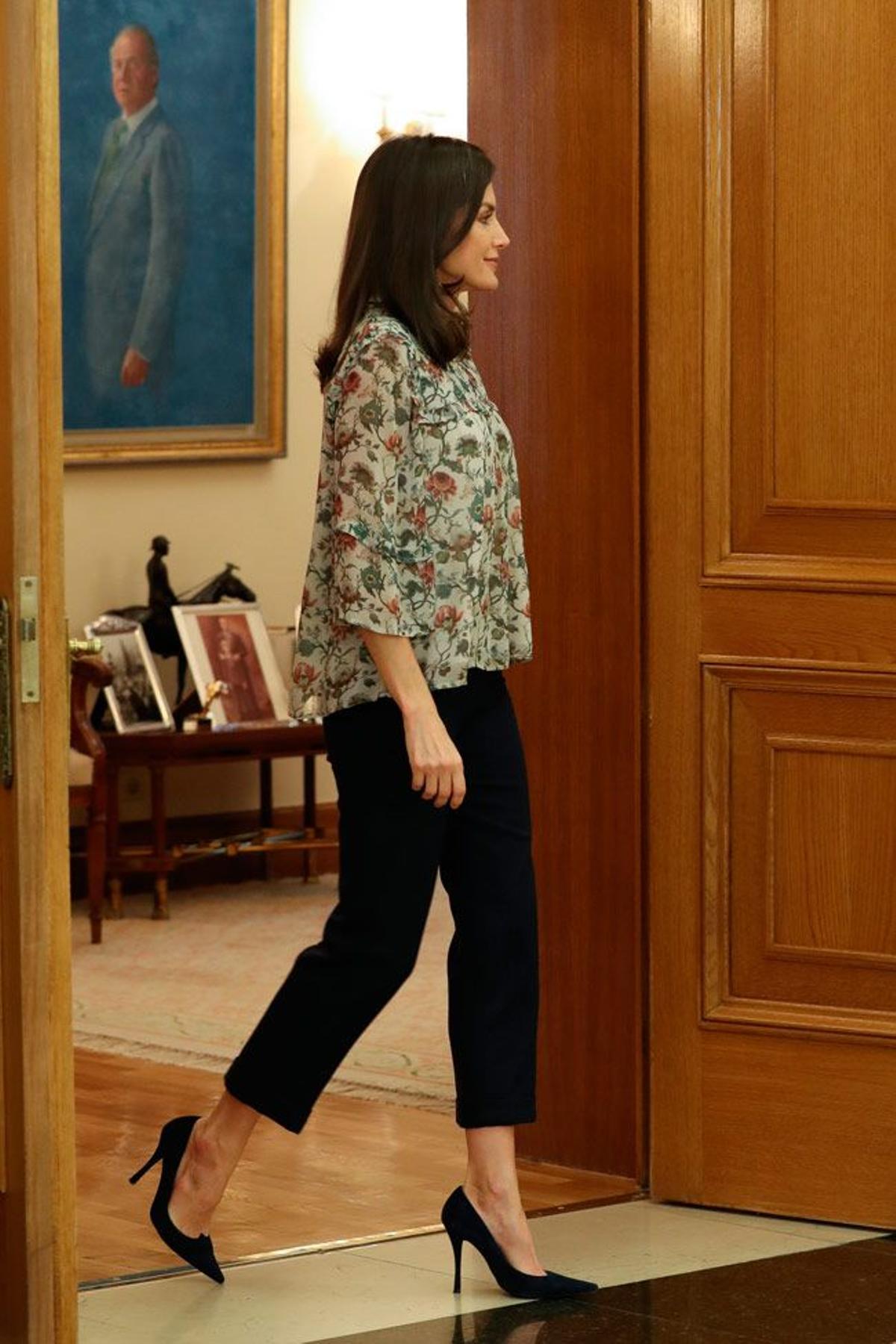 La reina Letizia con blusa de flores y pantalón negro que suma centímetros