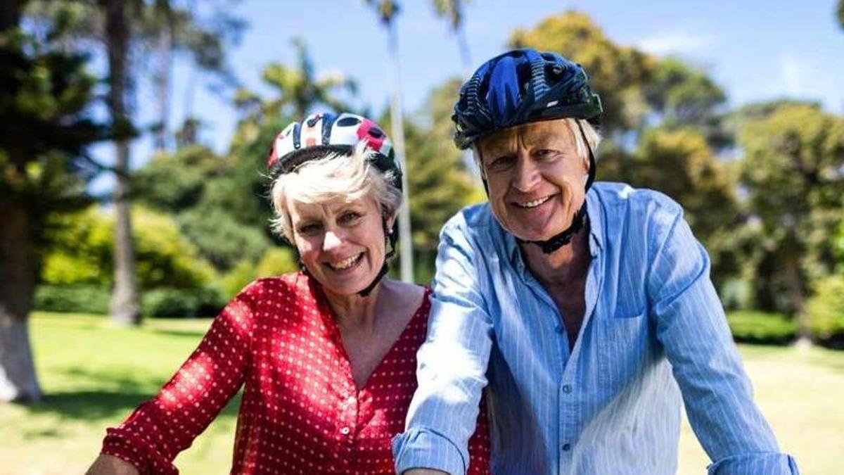 Una pareja de personas mayores a los 55 años disfrutando de una ruta ciclista