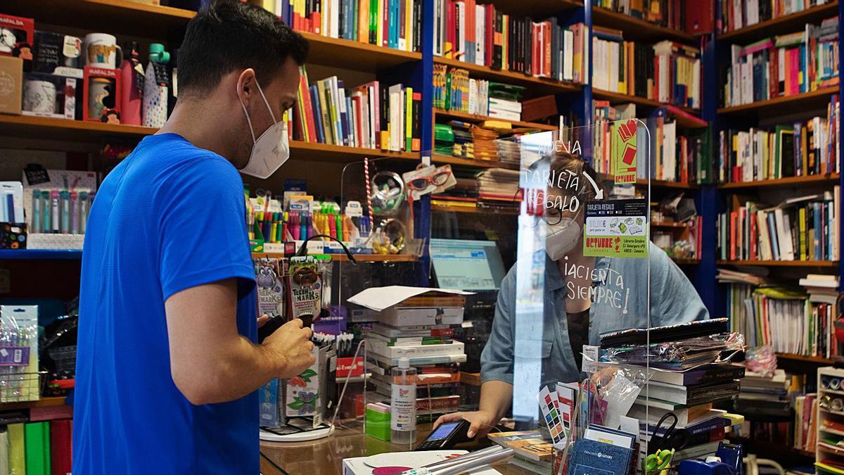 Un cliente compra diverso material escolar en una librería de la ciudad de cara al próximo curso.