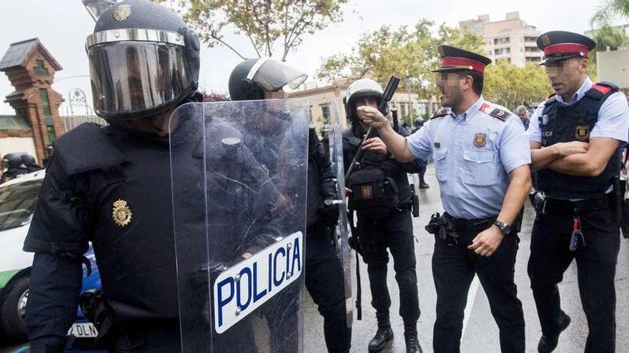 Agentes del Cuerpo Nacional de Policía y Mossos d&#039;Esquadra discuten acaloradamente durante los disturbios. // Efe