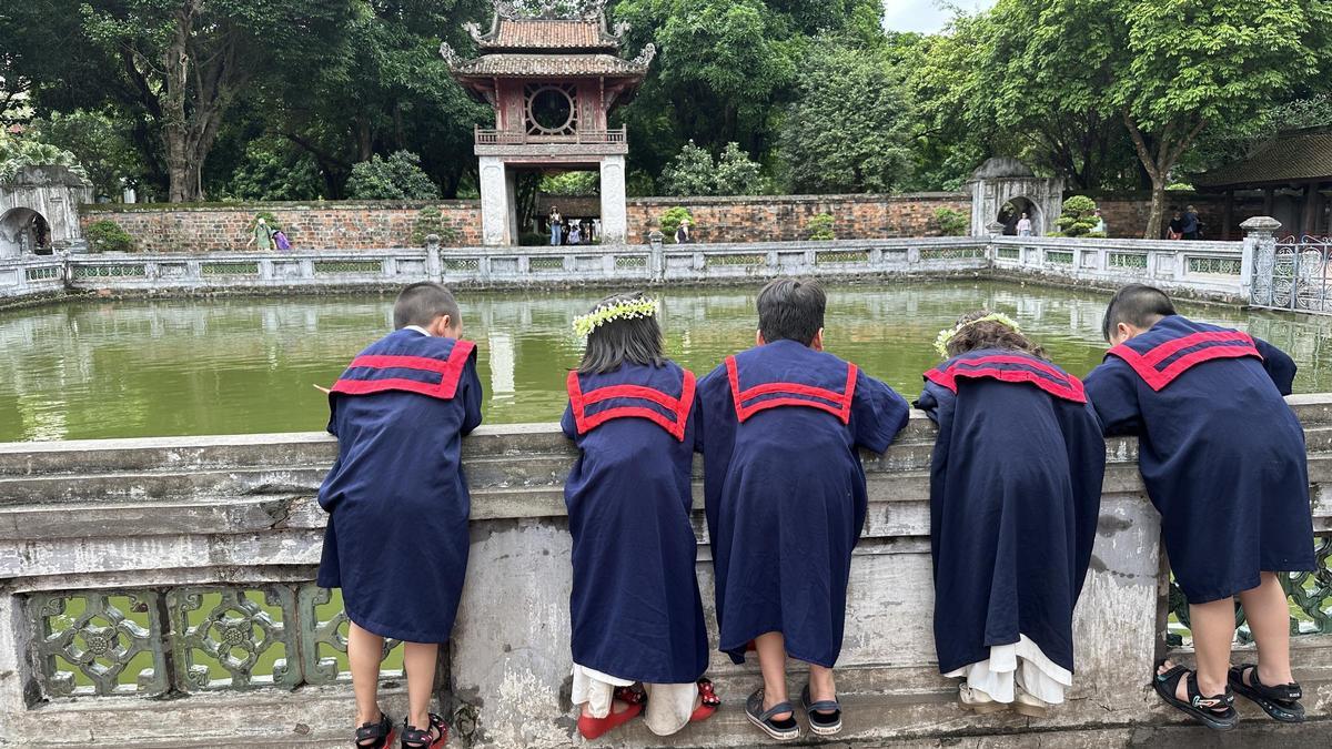 Escolares asomados al estaque del Templo de la Literatura