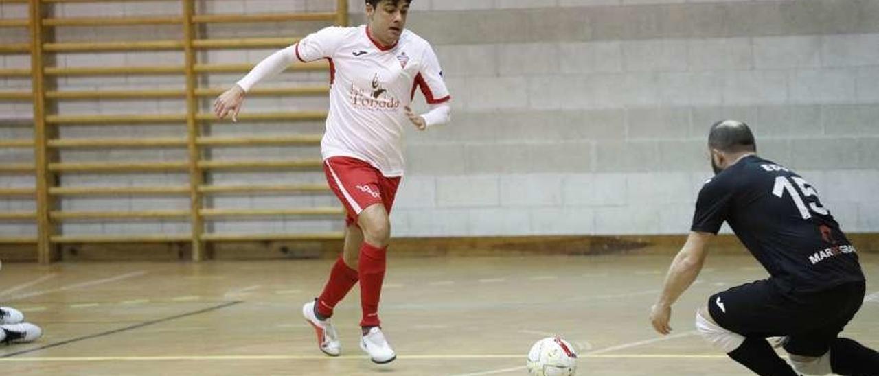 Un jugador del Gijón Playas trata de superar al portero del Cinco As.