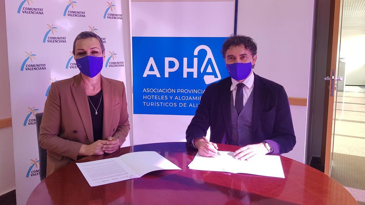 La presidenta de los hoteleros de Alicante, Victoria Puche, firmando un acuerdo con Francesc Colomer