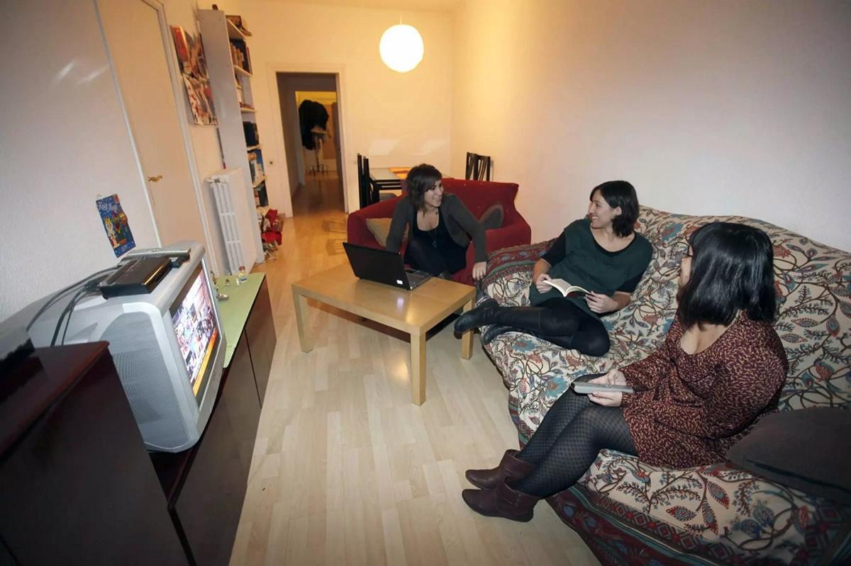 Jóvenes que comparten piso disfrutando de la comunidad en el salón.