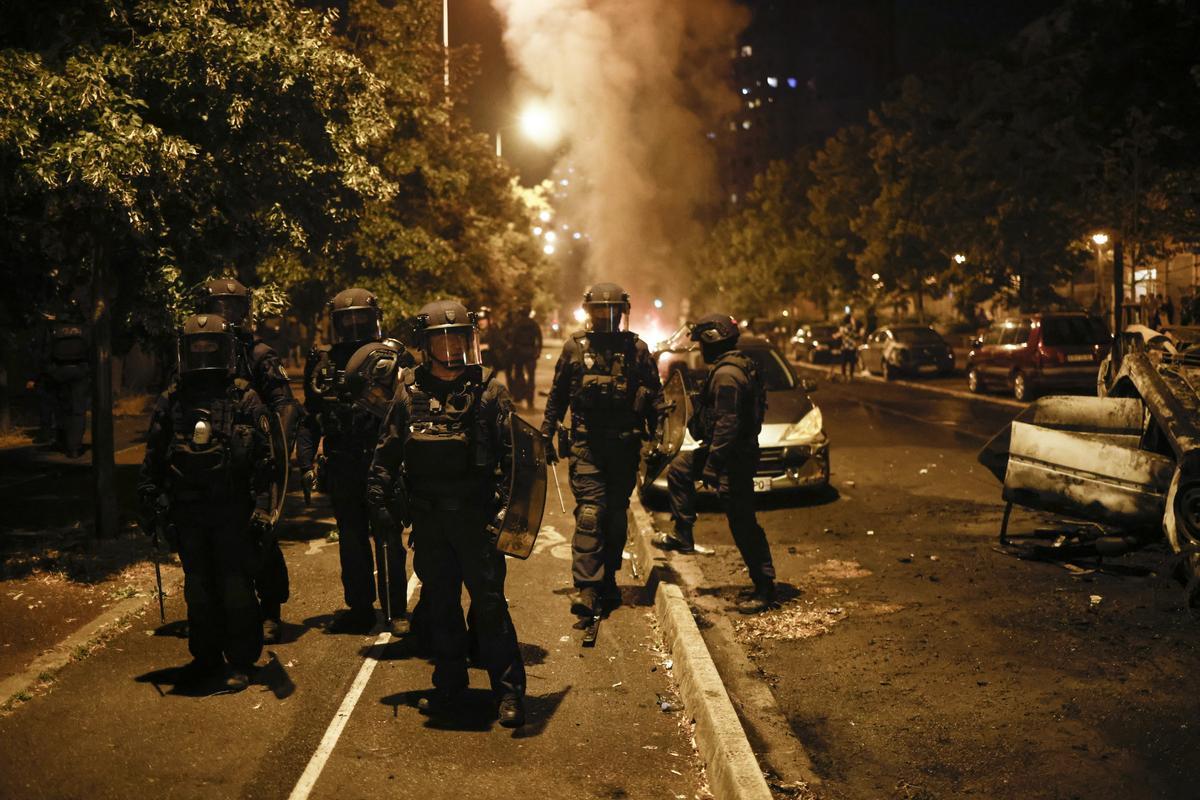 Policías antidisturbios junto a un vehículo incendiado en las protestas en Nanterre (France).EFE/EPA/YOAN VALAT