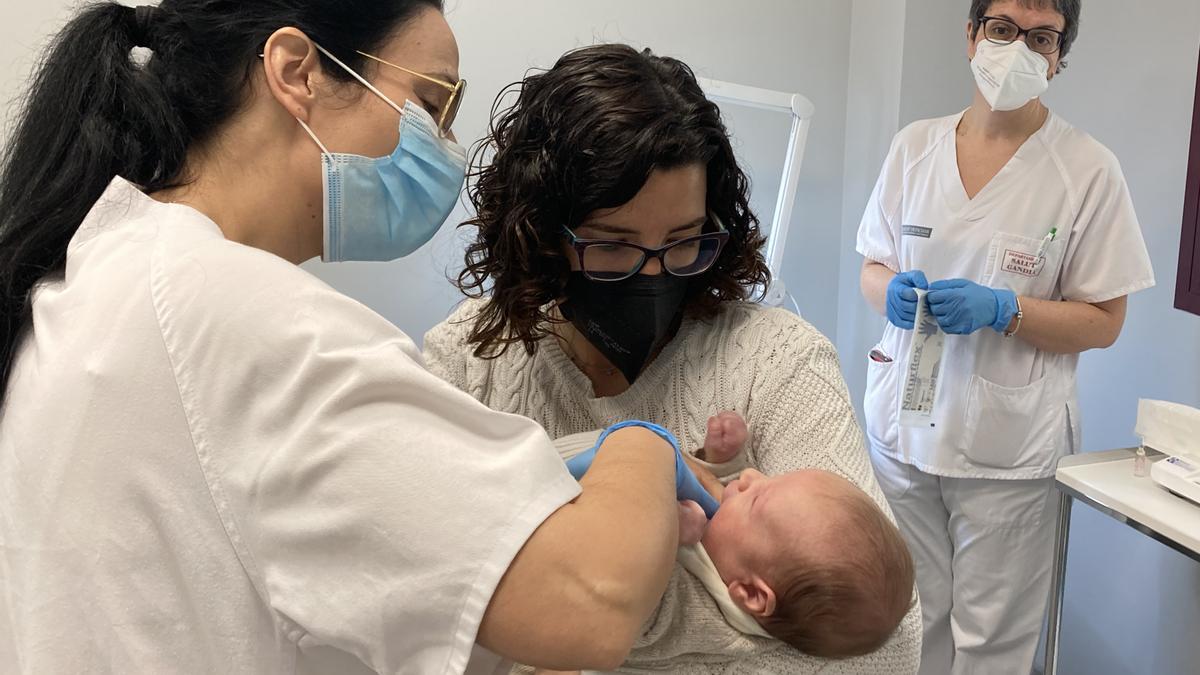 Una sanitaria atiende a un bebé en Gandia.