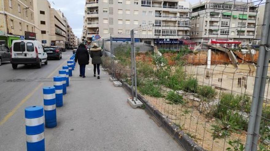 Solar con tramos de la valla perimetral desmoronados sobre el foso que dejaron las obras abandonadas.