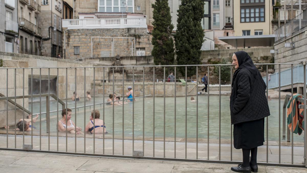 Una mujer mira a la piscina termal de As Burgas. // BRAIS LORENZO