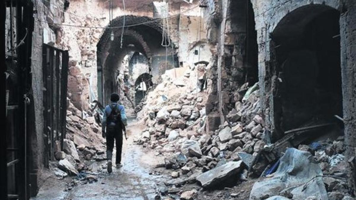Un miliciano camina por entre las ruinas que han dejado los bombardeos en el zoco antiguo de Alepo, una ciudad habitada desde hace 7.000 años.