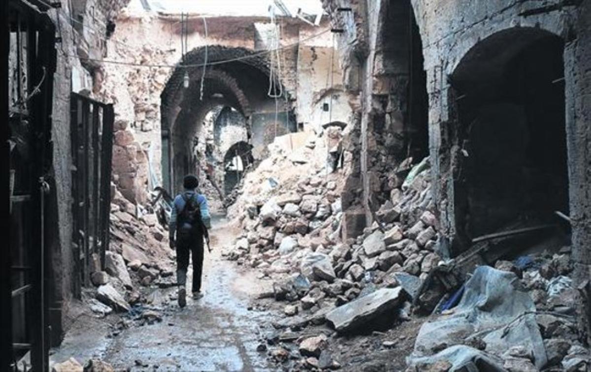 Un miliciano camina por entre las ruinas que han dejado los bombardeos en el zoco antiguo de Alepo, una ciudad habitada desde hace 7.000 años. Un miliciano camina por entre las ruinas que han dejado los bombardeos en el zoco antiguo de Alepo, una ciudad habitada desde hace 7.000 años.