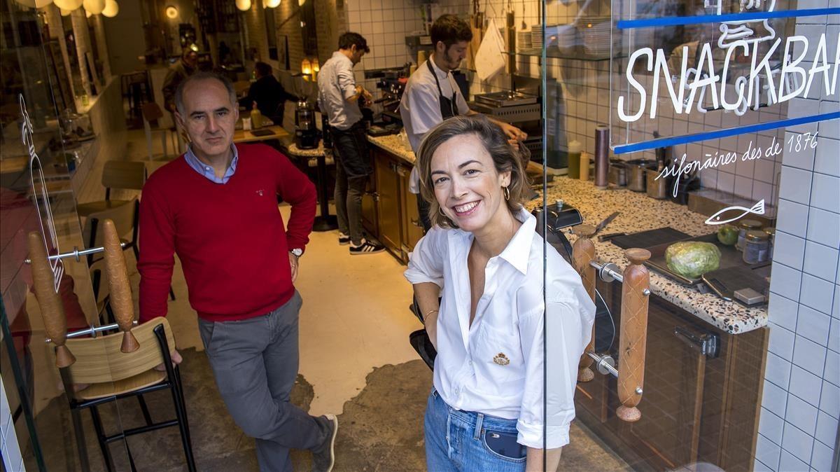 Olivier Guilland i Helena Garriga, a la porta d’El Sifó, amb un cuiner i el barista treballant darrere.