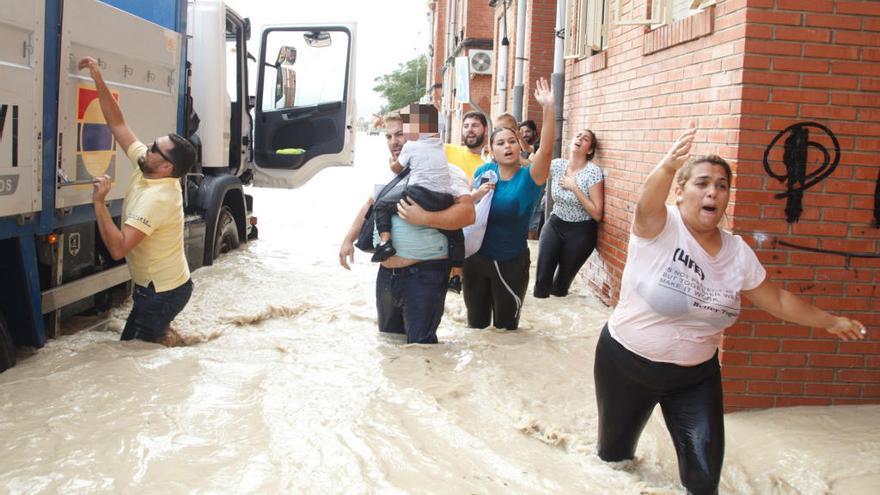 Una familia escapa de las riadas en Almoradí.