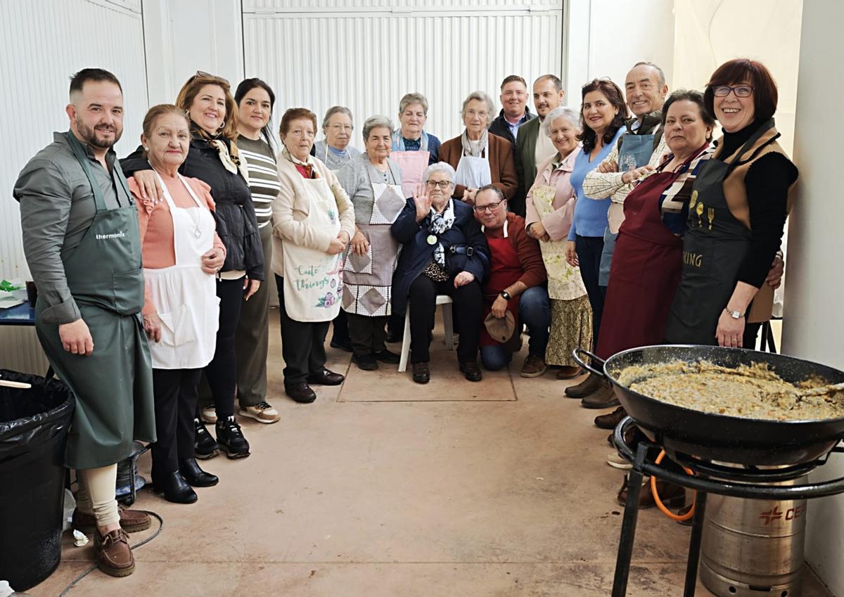 Un grupo de vecinos con un perol listo para degustar.