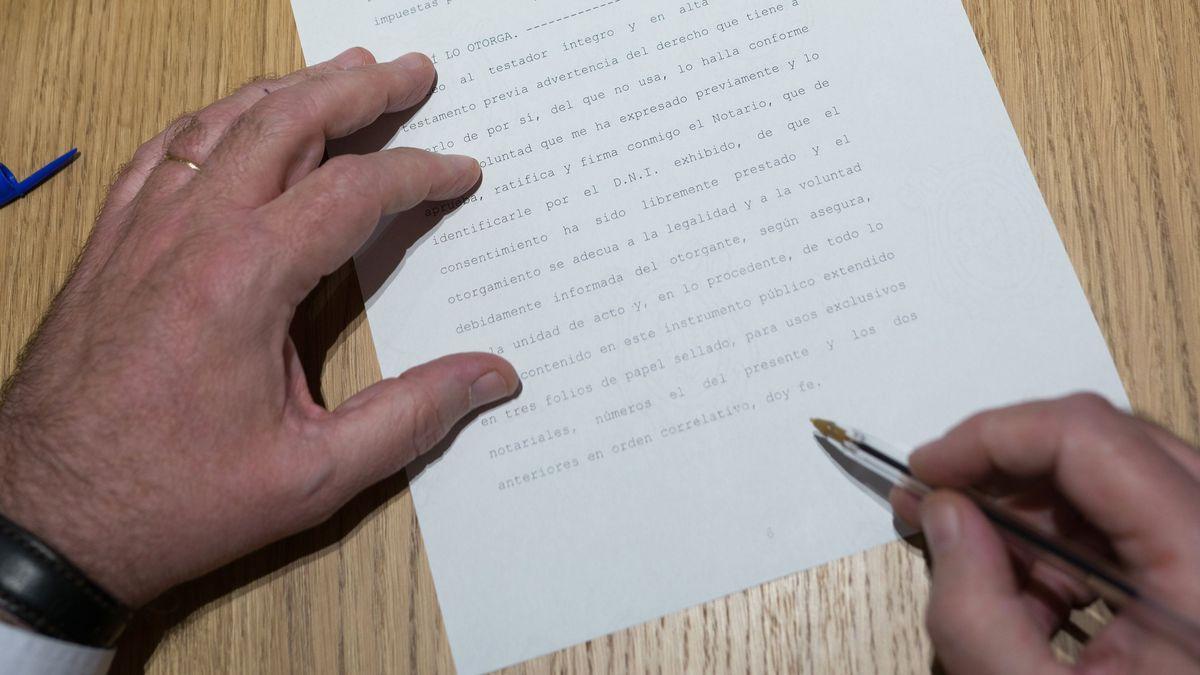 Una persona firma la escritura de un testamento ante notario.