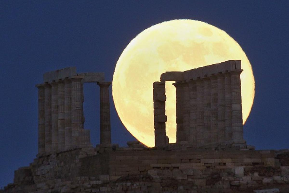 El templo de Poseidón, el antiguo dios del mar griego, con la luna de fondo en Cabo Sounión (Grecia).