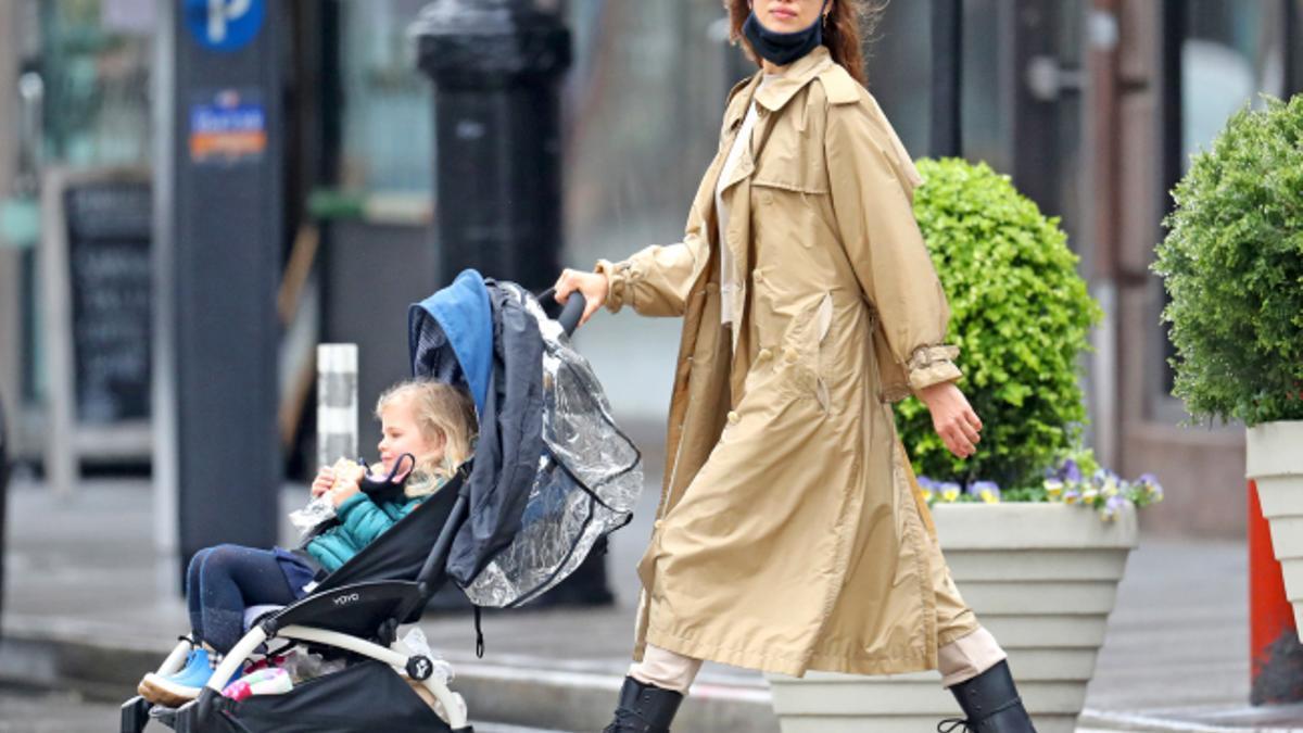 De look de Irina Shayk con chaqueta vaquera, falda midi y zapatillas de running blancas nos quedamos con su moño de bailarina con diadema