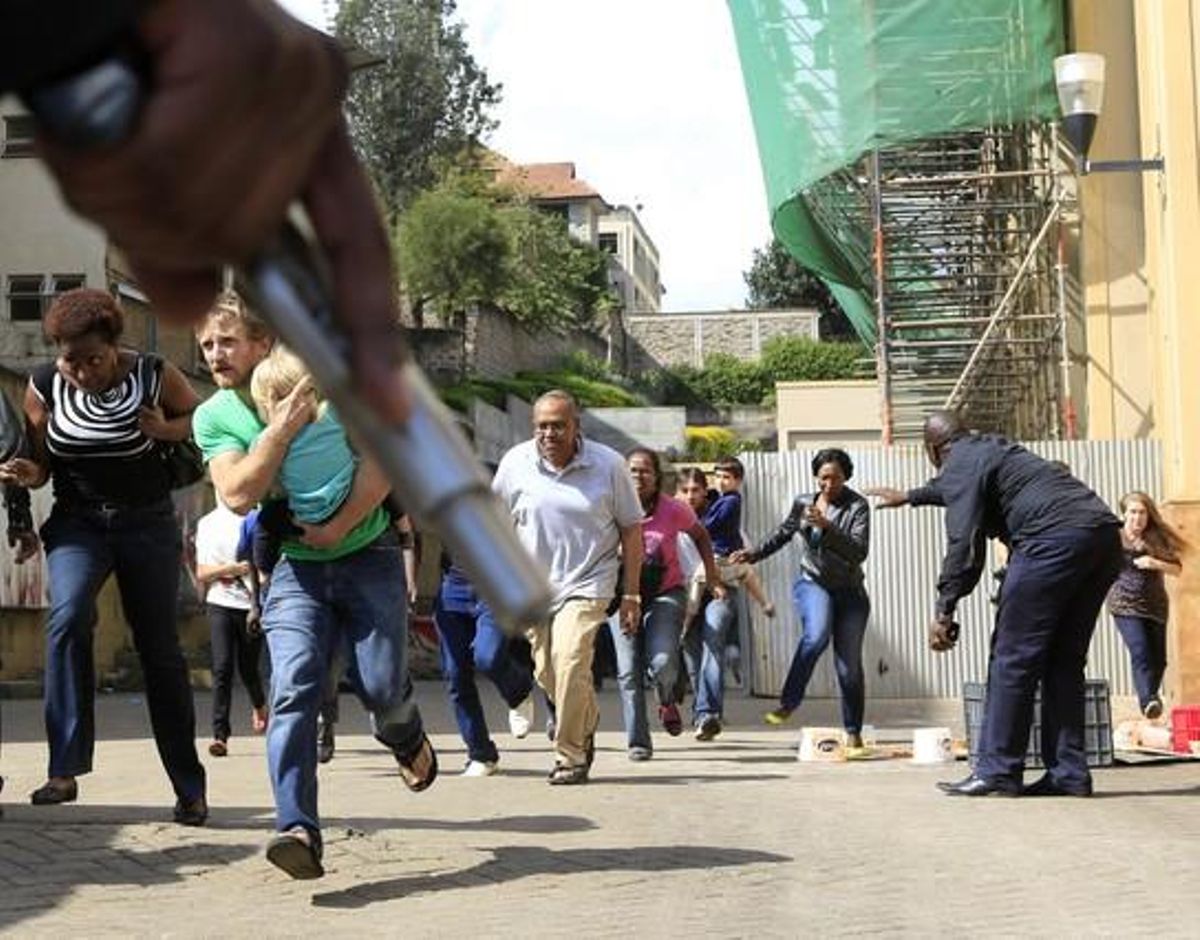 Un oficial de policia empunya la seva arma per protegir els clients que han aconseguit sortir il·lesos de l’assalt a Nairobi.
