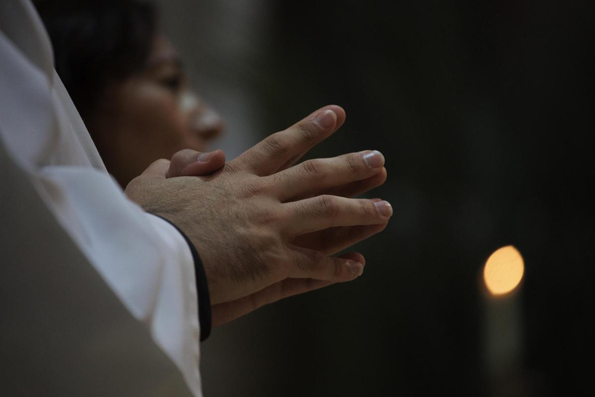 Manos de un cura en el interior del templo durante la beatificación de los doce misioneros redentoristas asesinados durante la Guerra Civil, en la Catedral de La Almudena, a 22 de octubre de 2022, en Madrid (España).