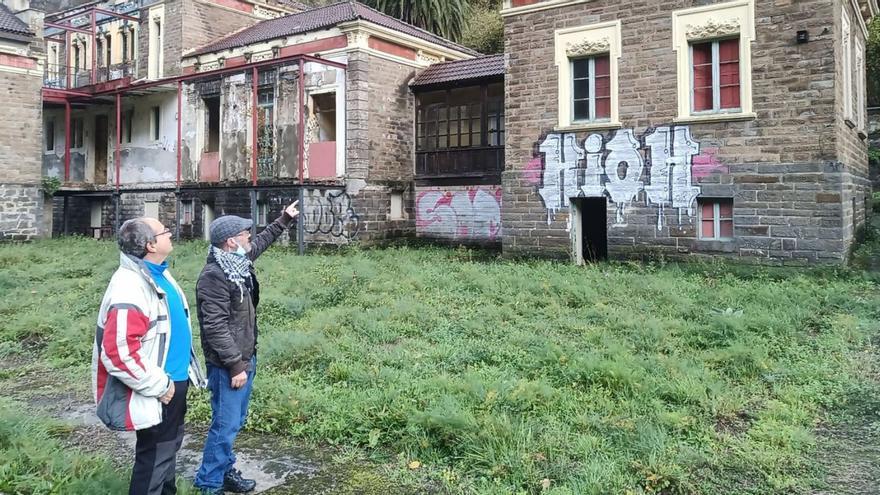 José Antonio Rubio y Manuel Alberto Vicente, mostrando la zona del sanatorio de Bustiello en la que han aparecido goteras. | D.M.