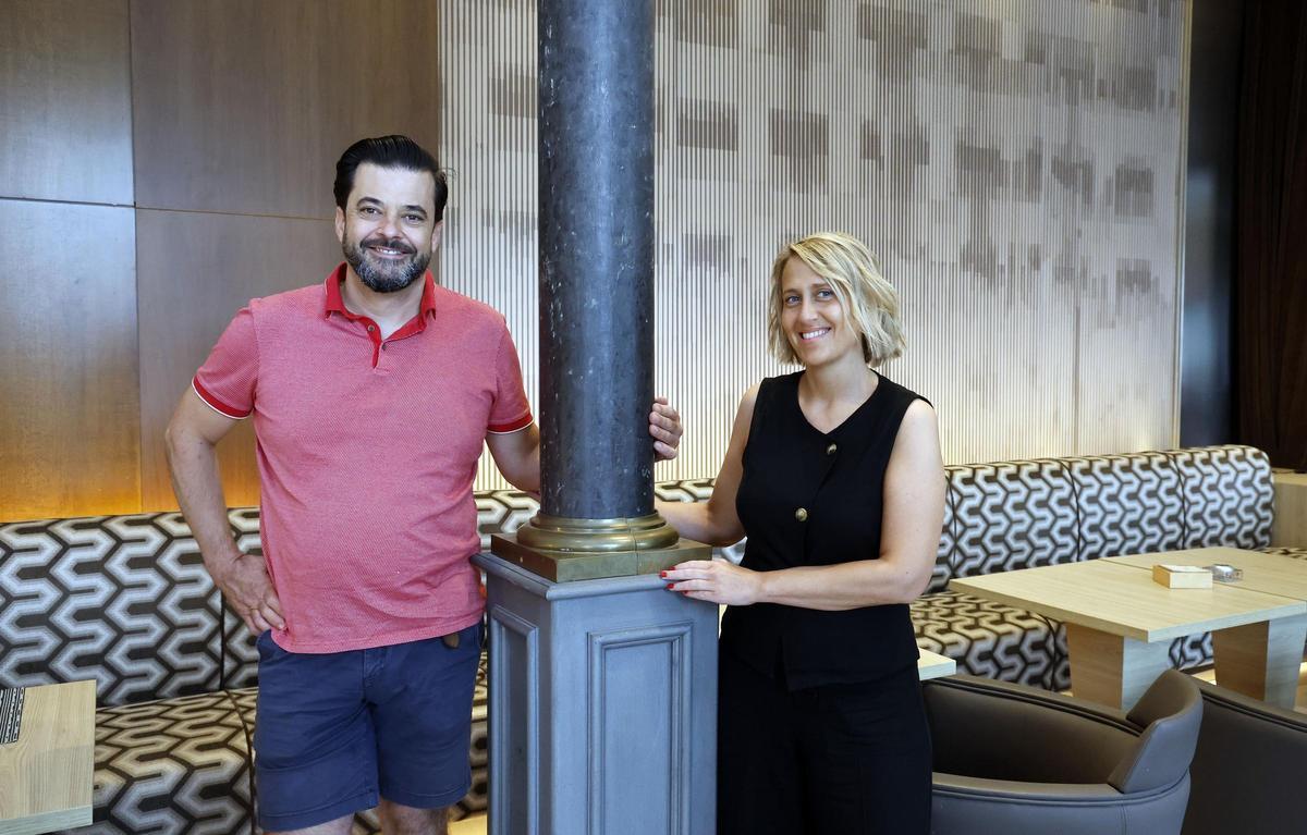 Los dueños de Silabario, el chef Alberto González Prelcic, y la jefa de sala Goretti Álvarez, ante un vinilo del hotel Universal que replica su fachada.