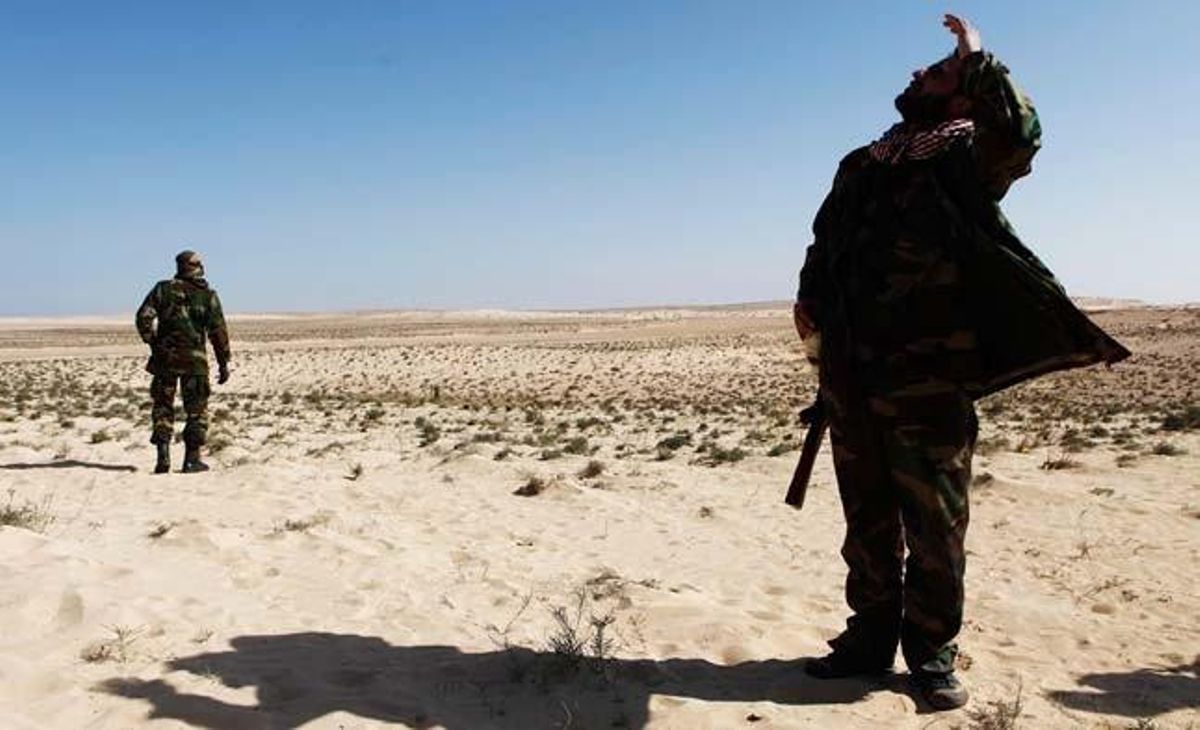 Un soldat rebel al front mira al cel per distingir els avions de l’OTAN.