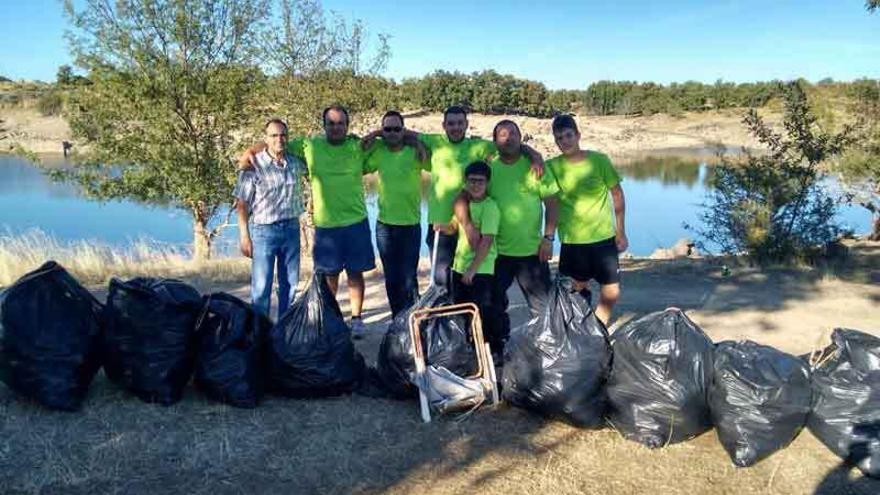 Un grupo de pescadores con las bolsas de basura recogidas en la zona de Pelazas.