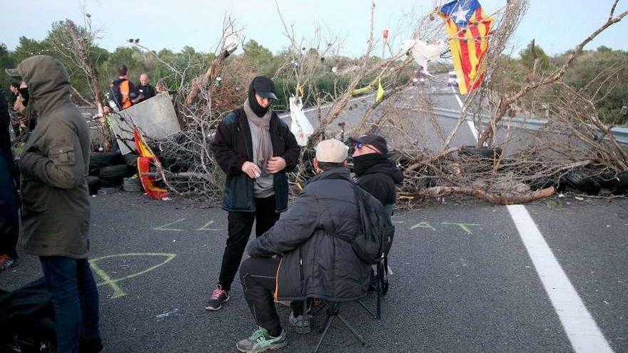 Miembros de los CDR tras la barricada para impedir el paso de los vehículos en la AP-7. // Efe