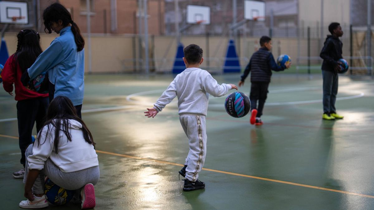 Niños jugando a baloncesto en una escuela.