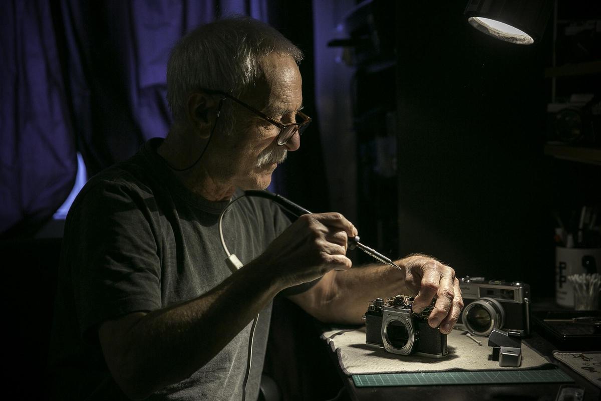 Larga vida a la fotografía analógica. El jubilado Enric Pareto repara cámaras antiguas en su taller de Barcelona con piezas de otras compradas a precio de saldo