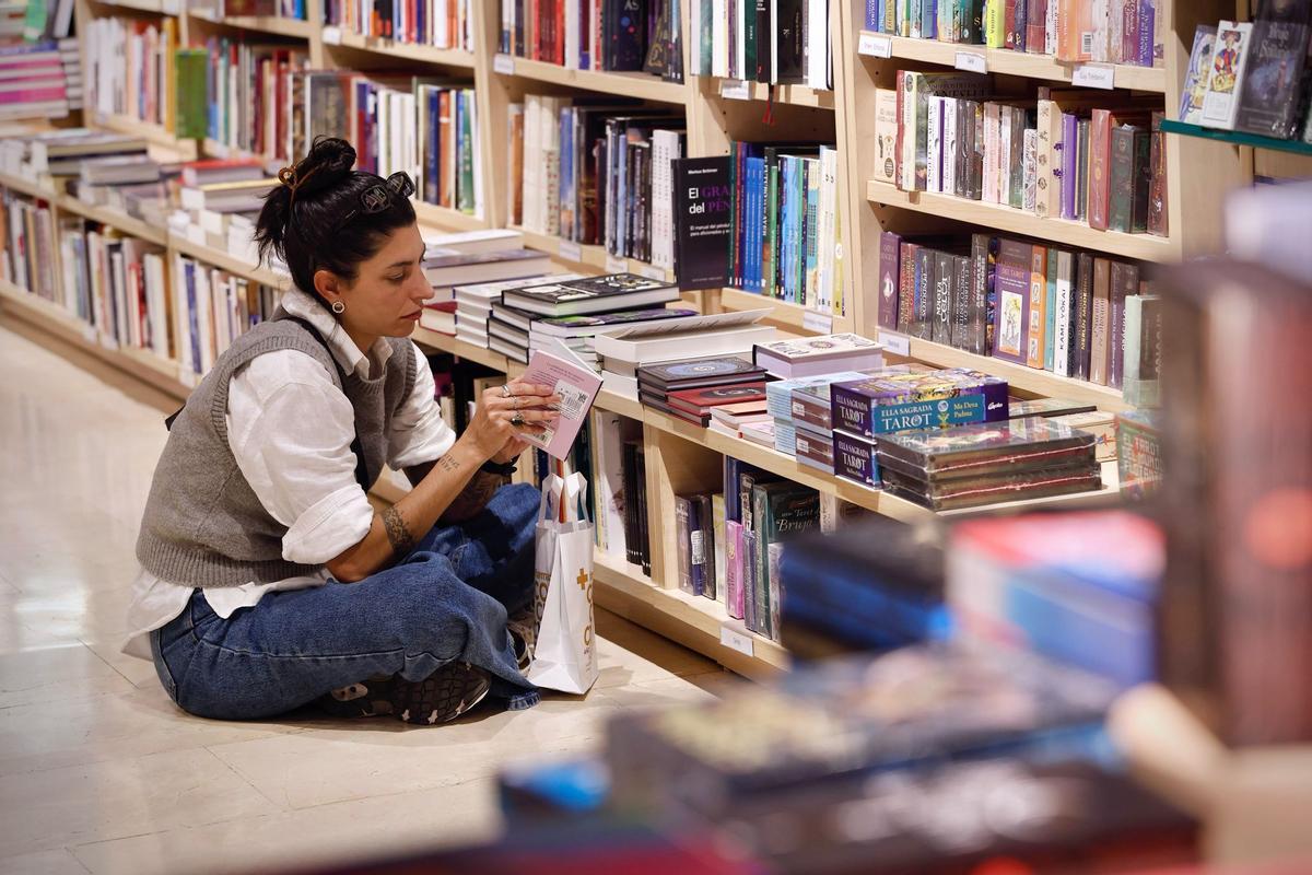 Una lectora ojea un libro en La Casa del Libro.