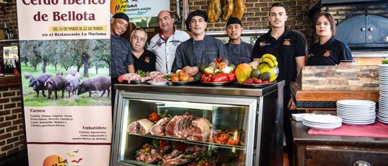 Gustavo Soba, en el centro, rodeado por sus compañeros en el restaurante La Marisma, Youi (izquierda), Roque, el propietario, Francisco Almeida, Dominique, Yeray y Verónica, junto a una muestra de carnes, que serán cocinadas en la parrilla.