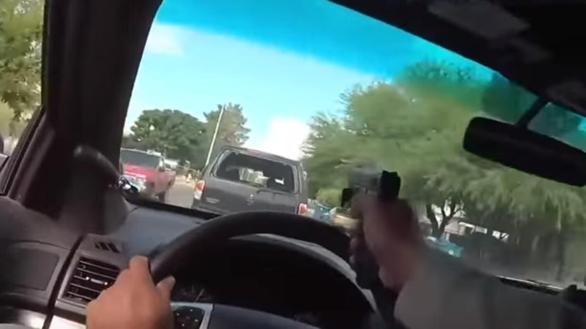 Un policía dispara a través de la luna de sus coche