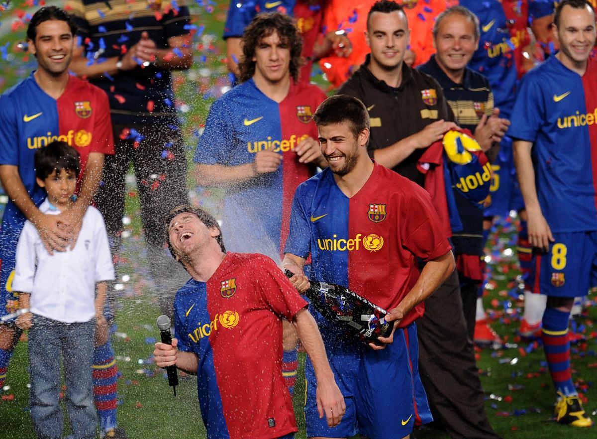 Celebración del título de liga del FC Barcelona en el Camp Nou en 2009. Piqué riega con cava a Messi, tras su intervención.