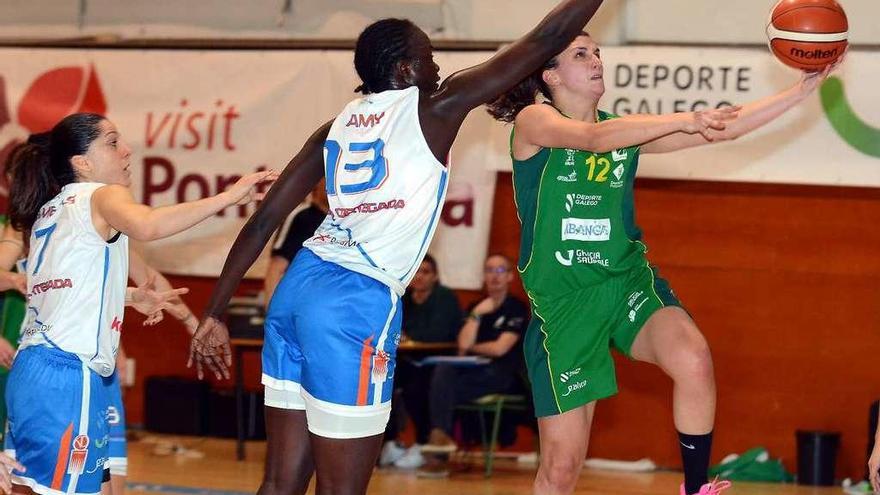 María Lago entrando a canasta ante el intento de tapón de Amy Syll. // Rafa Vázquez