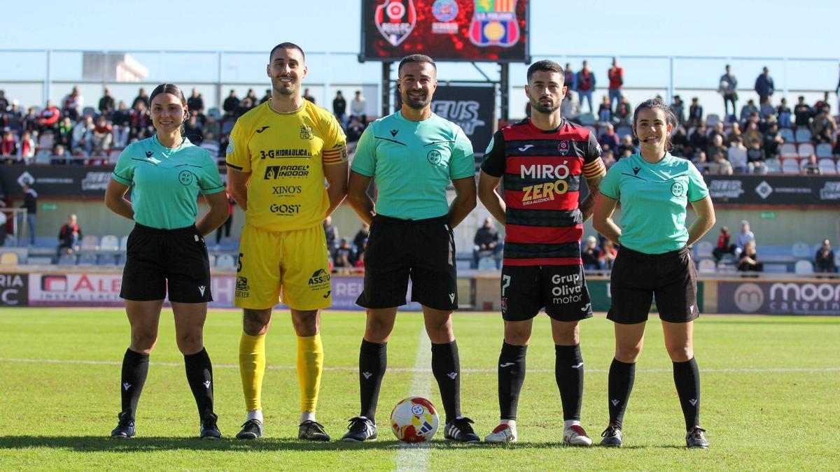 Los capitanes de Poblense y Reus posan con el trío arbitral antes del partido
