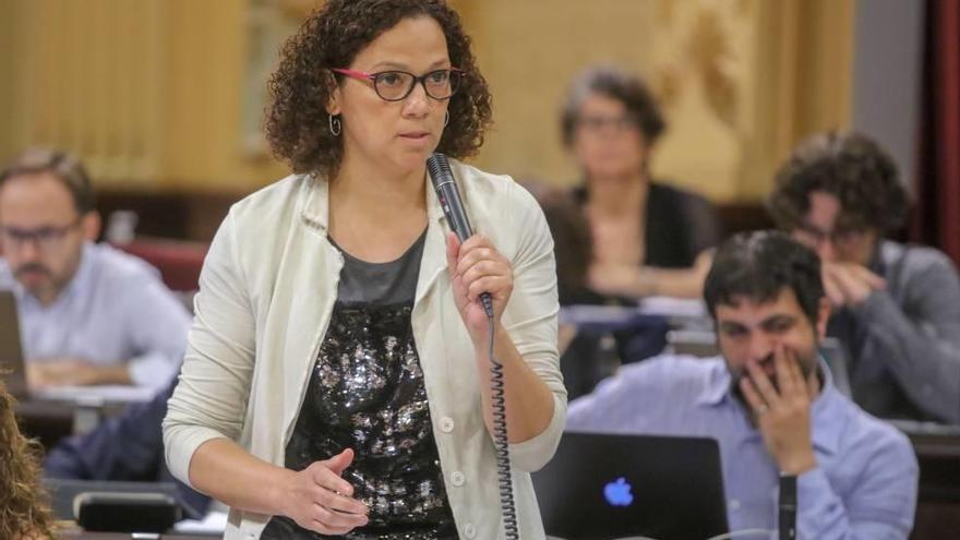 La consellera Cladera en su escaño en un pleno del Parlament frente al portavoz de Més, Josep Ferrà.