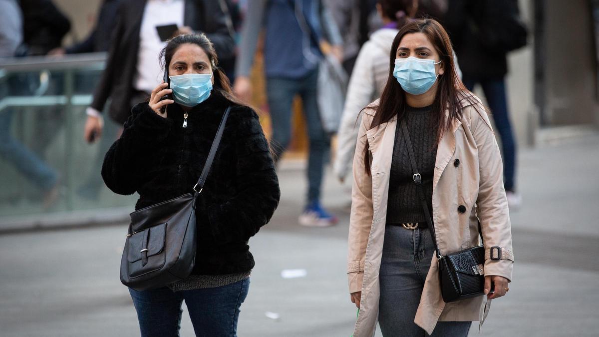 Dos mujeres llevan mascarilla en Barcelona durante un repunte del virus.