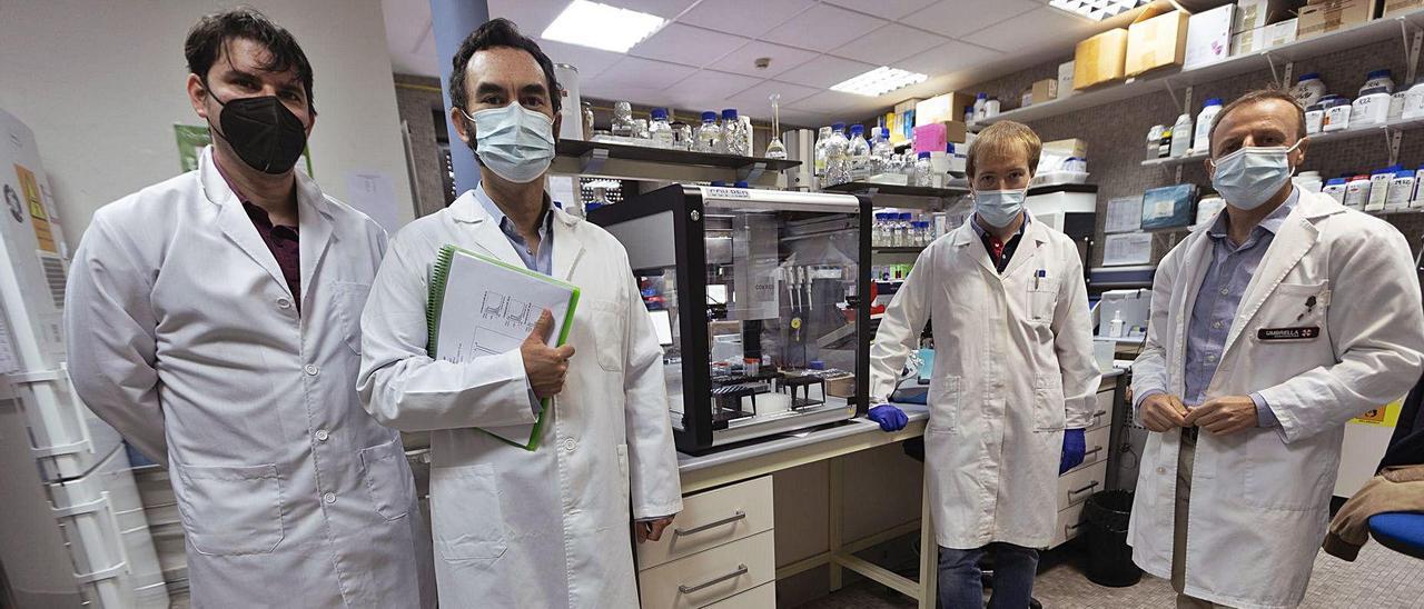 Por la izquierda, Alberto García y Francisco García Carro, de la ingeniería Magna Dea, y Javier Fernández y Felipe Lombó, de la Universidad de Oviedo, con su prototipo de detección del covid en aguas residuales, en un laboratorio de la Facultad de Medicina.