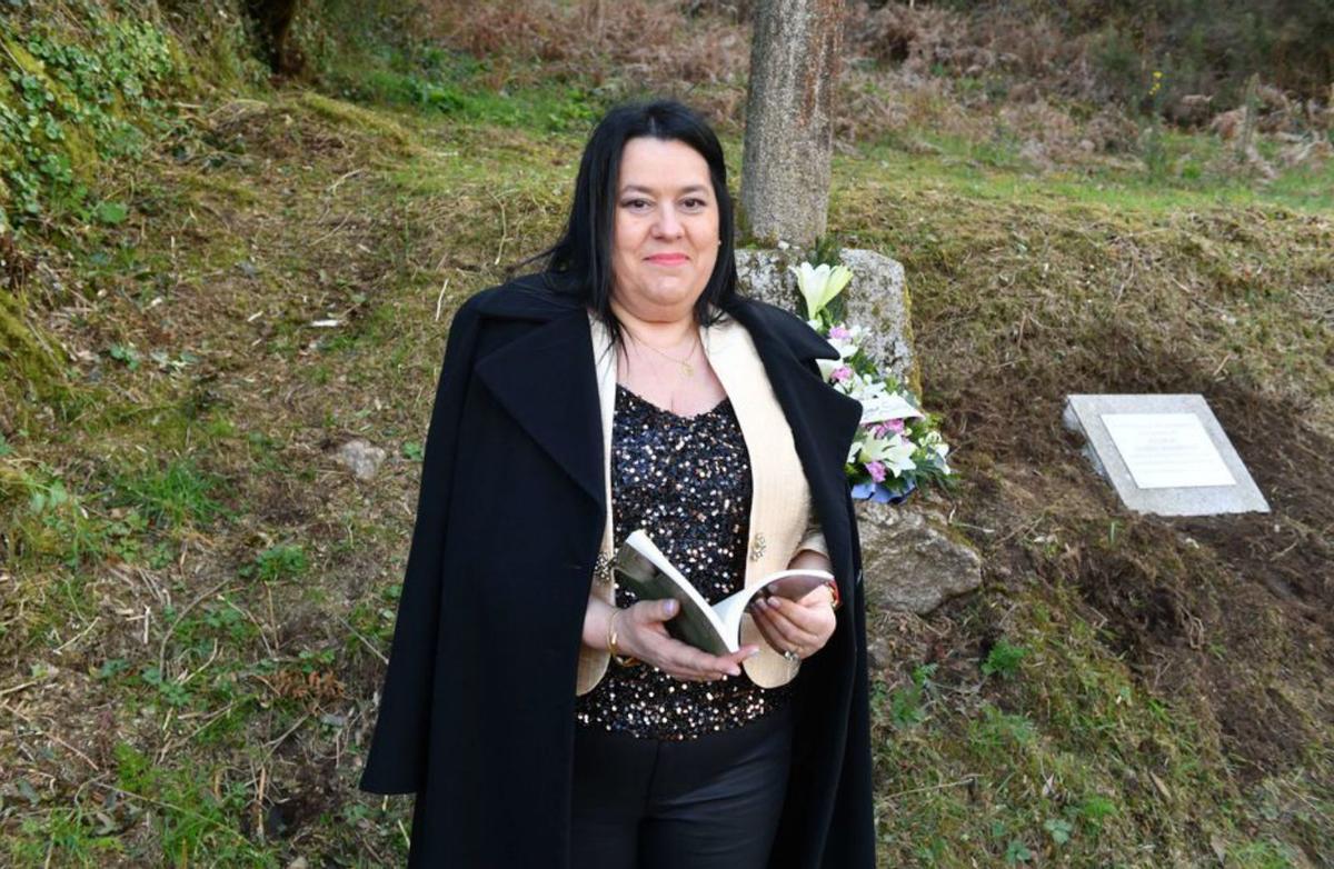 Sandra Aldao posa con su libro frente al cruceiro. | Iago López