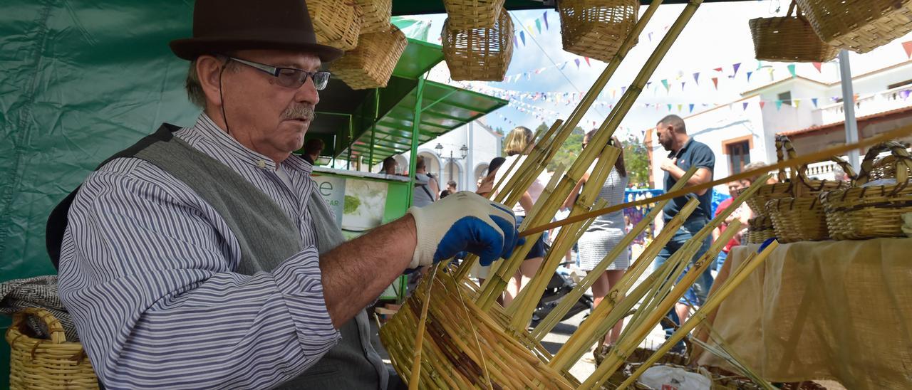 Un artesano fabrica una cesta de mimbre en la Feria agrícola y artesana de Fontanales, Gran Canaria.