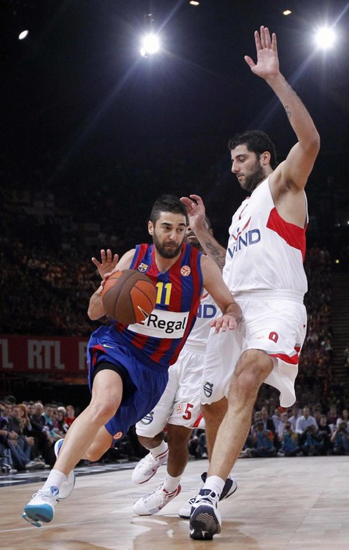 El jugador del FC Barcelona Juan Carlos Navarro maneja el balón ante la marca de Ioannis Bourousis (d), del Olympiacos, el domingo 09 de mayo de 2010, durante el partido por la final de la Euroliga de baloncesto en Bercy, París (Francia).