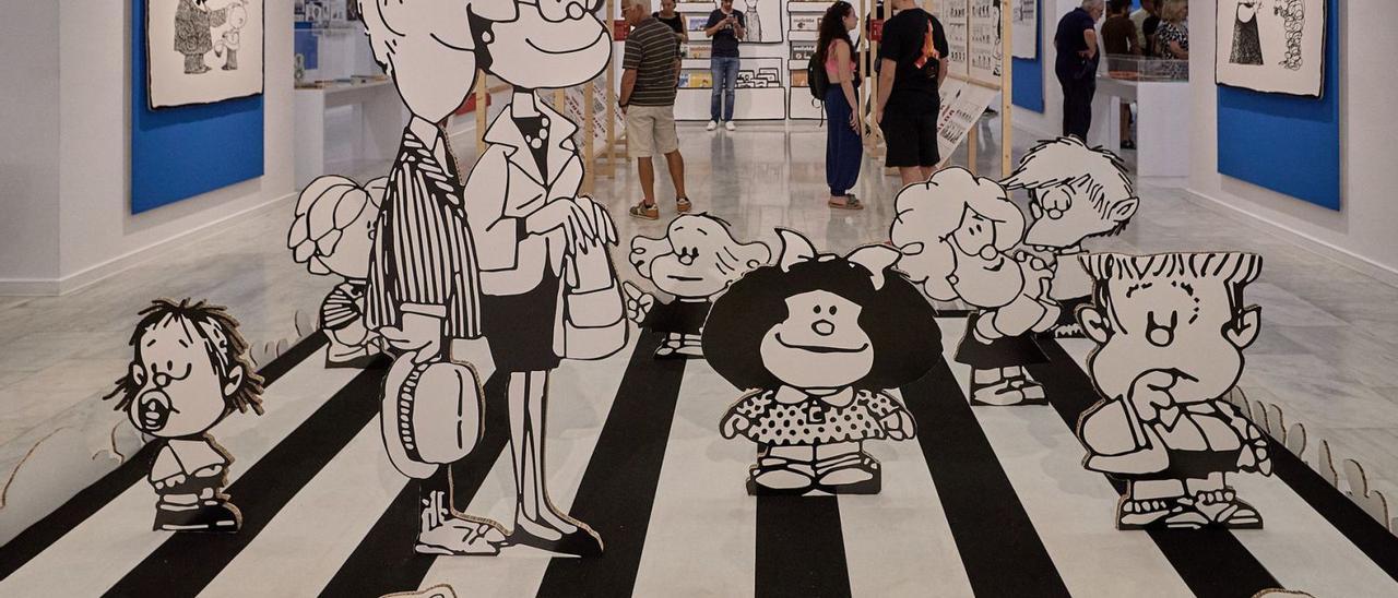 Los populares personajes de la muestra de Mafalda en la Casa de la Marquesa de Gandia, con un grupo de visitantes al fondo. | NATXO FRANCÉS